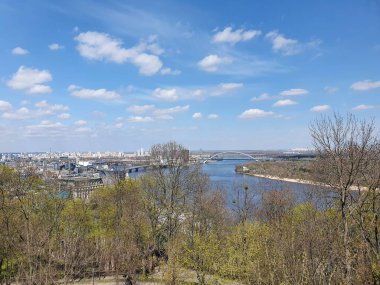 Tarihsel Podil mahallesi, hareketli şehir Kyiv ve Volodymyrska Tepesi 'nin avantajlı noktasından görkemli Dnipro Nehri manzarası. Fotoğraf bahar mevsiminde çekildi.