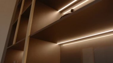 Parlak dolap rafları. Stok görüntüleri. Parlak ışık çizgileriyle modern iç tasarım. Dolabın raflarında parlayan lambalar. 