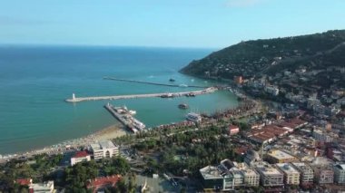 Deniz kıyısında küçük bir güney kasabasının havadan görünüşü. Şarjör. Deniz armudu ve turkuaz su, yeşil şehir ve tepeler