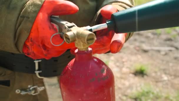 消防员用灭火器的特写 消防员拿起灭火器 去扑灭火 夏天大自然中的消防员 — 图库视频影像