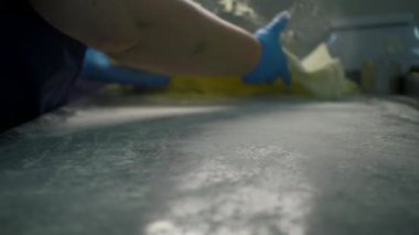 İnce hamurla pişirilen aşçıya yakın çekim. Şarjör. Yemek pişirmek için ince hamurlu. Kadınlar ince hamur gerer. Endüstriyel fırın. 