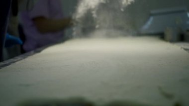 Pişirme sırasında serpiştirilmiş un. Şarjör. Pişirme masasına un serperim. Pişirmek için un serpiyorum. Üretim fırını. 