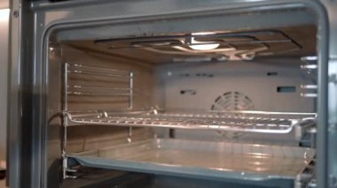 Yemek pişirme kavramı. Başla. Isıtmalı bir soba, tavayla tepsinin içine itiliyor. Yüksek kalite 4k görüntü