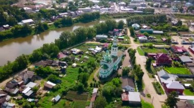 Yazın şehrin en güzel kilisesinin nehri manzarası. Şarjör. Güneşli bir günde kasabada nehir kenarındaki eski renkli kilise. Yazın nehir ve antik kiliseleri olan güzel bir şehir manzarası.. 