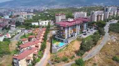Yeşillikler arasında pek çok evi olan resim gibi bir yaz şehri. Şarjör. Parlayan güneşin altında binalar ve bitkiler