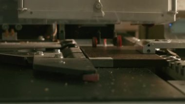 Tahtadaki otomatik sondaj makinesine yakın çekim. Yaratıcı. Ahşap ürünleri üretimi için otomatikleştirilmiş makine. Tahta tahtalardaki delikler için delme makinesi. 