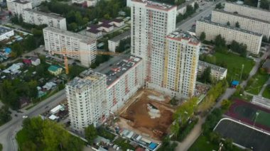 Şehrin arka planındaki nehrin yanındaki inşaat alanının en üst görüntüsü. Stok görüntüleri. Ufuk 'un arka planında nehir ile birlikte bir konut inşaatı. Şehirdeki binaların inşaatı