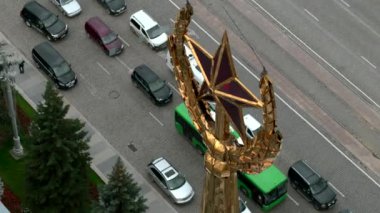 Sovyet sembolü, hareket eden arabalarla dolu bir caddenin arka planında altın kule. Stok görüntüleri. Altın yıldız ve buğday kulakları