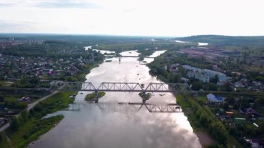 Şehirle nehir üzerindeki köprülerin üst görüntüsü. Şarjör. Şehir bölgeleri nehir ve köprülerle ayrılmış. Güneşli yaz gününde köprüleri olan iki şehir arasında nehir.. 