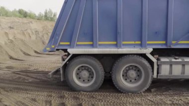 Minsk-Belarus, 18.11.2022: sahne. Yüksek tekerli mavi bir kamyonda çimento taşıyan bir taş ocağında inşaat. Yüksek kaliteli FullHD görüntüler