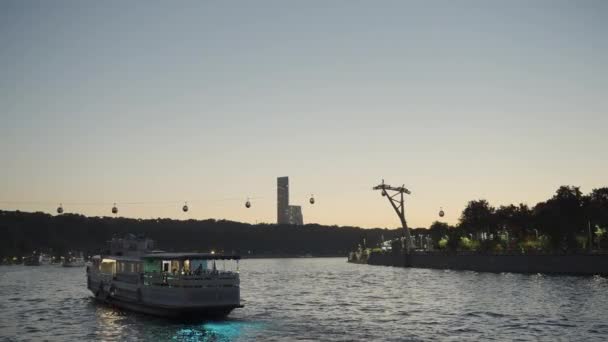 エンバンクに沿って航海する観光ヨットとサンセットの風景 アクション 川の上を移動するケーブルカー — ストック動画