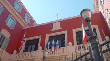 Fransa 'daki hükümet binası. Başla. Yukarıdan mavi gökyüzüne karşı bayraklarla süslenmiş küçük kırmızı bir bina. Yüksek kalite 4k görüntü