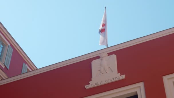 那栋大红楼行动 政府大楼顶部是红色的 有一面装饰过的国旗 在风中飘扬 高质量的4K镜头 — 图库视频影像
