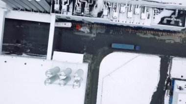 Helikopterden görüntü. Yaratıcı. Endüstriyel fabrikaların yanında hareket eden uzun renkli kamyonlar farklı yönlere dönüyorlar. Yüksek kalite 4k görüntü