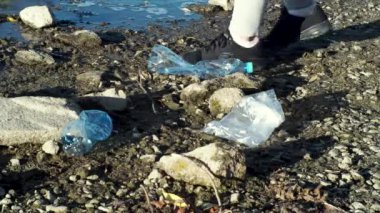 Plajda plastik temizleme ekibi çalışması. Hareket. Gönüllüler nehir kıyısından, plastik kirliliği ve çevre sorunları kavramından çöp topluyorlar