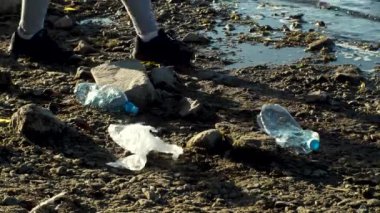 Plajda plastik temizleme ekibi çalışması. Hareket. Gönüllüler nehir kıyısından, plastik kirliliği ve çevre sorunları kavramından çöp topluyorlar