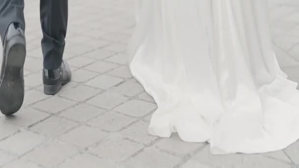 详细的婚纱照行动 亲吻新婚夫妇的轮廓和他们穿着经典服装在街上走着 高质量的4K镜头 — 图库视频影像