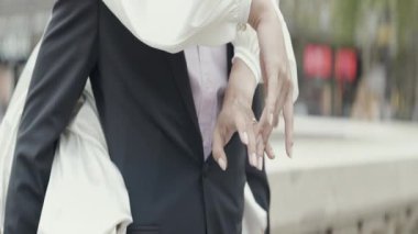 Dans eden neşeli çift. Başla. Beyaz elbiseli güzel bir esmer ve nişanlısı inşa edilmiş bir şehrin meydanında gülüp eğleniyorlar. Yüksek kalite 4k görüntü