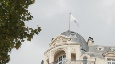 Fransa, Paris - 29 Temmuz 2022: Yeşil ağaçlı eski Avrupa evinin alt manzarası. Başla. Paris 'te Apple bayrağı olan eski binanın dışı. Apple Store ile Şanzelize 'deki Ev. 