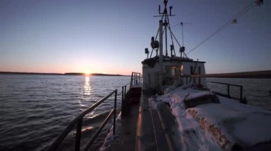 Deniz manzaralı bir balıkçı teknesinde. Şarjör. Ufuk manzaralı bir balıkçı teknesinde yürüyorum. Balıkçı teknesi ufuktaki güneşin arka planına yelken açıyor. 