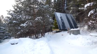 Ormanda bir ev. Şarjör. Kışın ormanda üçgen bir kır evi. Kışın ormandaki modern kır evinin inşaatı.