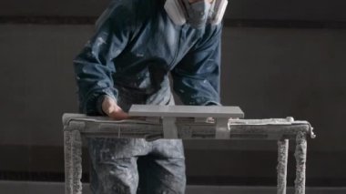 Tamir konsepti. Yaratıcı. Üniformalı bir adam dükkanları topluyor ve kapalı bir odada resim yapıyor. Yüksek kalite 4k görüntü