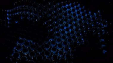 Hareket eden kristalleri olan karanlık bir arka plan. Tasarım. Animasyondaki beyaz ve mavi kristaller dalgalarda hızlı hareket eder. Yüksek kalite 4k görüntü