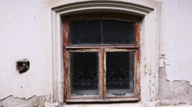 Eski karanlık bir pencere. Stok görüntüleri. İçinde ışık olmayan karanlık bir pencerenin gün ışığında çıkarıldığı eski beyaz bir ev. Yüksek kalite 4k görüntü