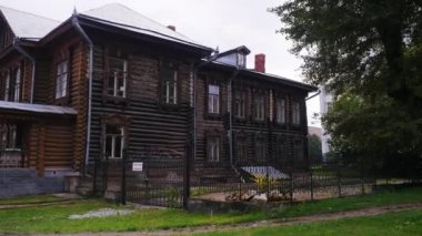Eski ahşap bir ev. Stok görüntüleri. Vatandaşların yürüdüğü parkın arka planında ışıksız duran ahşaptan yapılmış iki katlı büyük bir ev. Yüksek kalite 4k görüntü