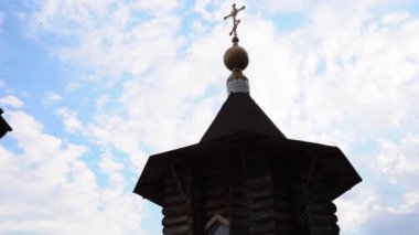 Kilisenin eski ahşap kulesi. Medya. Arka plandaki antik kilisenin ahşap kulesi. Bulutlu bir günde haçlı ahşap kilisenin mimarisi. 