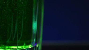 Yumuşak içecek, mavi arka planda izole edilmiş yeşil soda. Borsa klipsi. Suyun içinde kabarcıklar