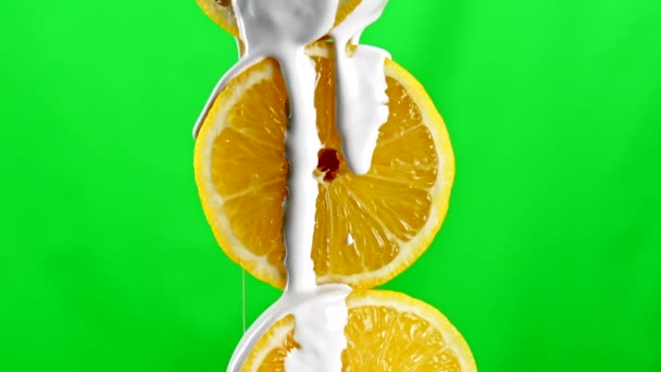 融化的香草冰淇淋流下来 覆盖着一半新鲜切碎的橙子 库存夹 在绿色色键背景上分离的果实 — 图库视频影像