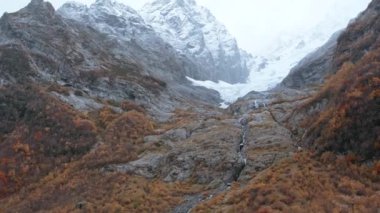 Kurumuş otlarla nefes kesici sonbahar manzarası. Yaratıcı. Sabah sisinde dağın zirvesinde kar.