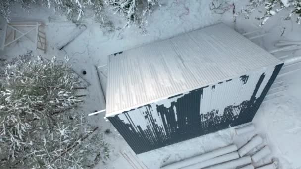 冬の森の家の建築現場のトップビュー クリップ 冬の密集した森で建設中の家 冬の荒野でのシングルハウスの建設 — ストック動画