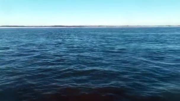 在蓝色波浪中从移动的船上看到美丽的景色 地平线上海岸背景上蓝色海浪的令人叹为观止的景象 蓝波上的快速移动 — 图库视频影像