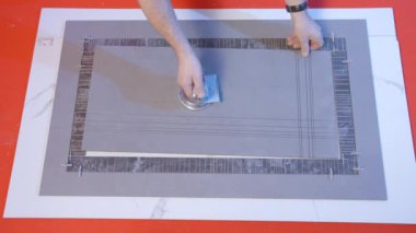 İşçi kiremit desenini bağlar. Yaratıcı. Adam kare tahtaların detaylarını birbirine bağlıyor. İnsan tahta ve döşeme kalıbına katılır. 