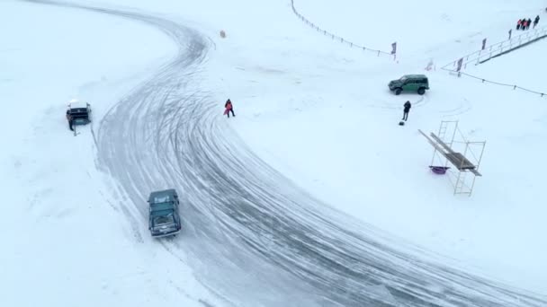 空中俯瞰雪地上飘浮的汽车覆盖了整条公路 在结冰的湖上进行冬季赛跑 — 图库视频影像