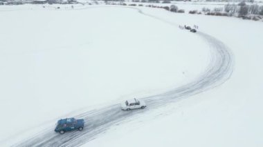 Karda sürüklenen arabaların off-road üzerindeki hava manzarası. Şarjör. Donmuş gölde kış yarışı