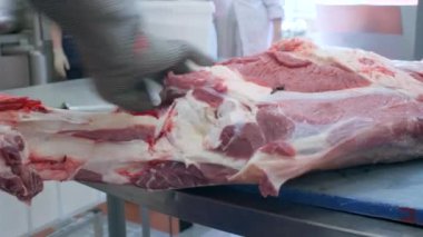 Domuz eti kesen bir kasap elleri. Şarjör. Etin ve gıda endüstrisinin kemiklerini kesen işçilere yakın çekim