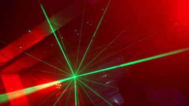 Gece kulüpte parlak lazer hatları. Şarjör. Gece kulübünde yeşil lazerlerle dans pisti. Parlak lazer çizgileri gece kulübünde parlıyor.. 