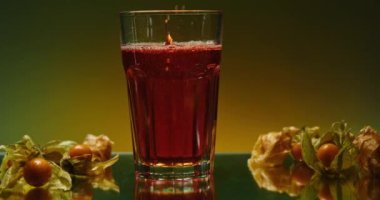 Şeffaf bardakta parlak bir içecek. Borsa klipsi. Kabarcıklar ve malzemelerle birlikte iç. Barın atmosferinde bardakta parlak bir içki. 