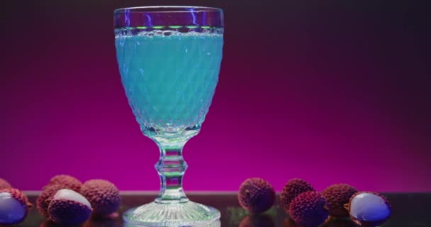 透明玻璃杯中清澈爽口的饮料 库存夹 满地都是泡泡和配料 酒吧气氛中的酒杯中鲜亮的饮料 — 图库视频影像