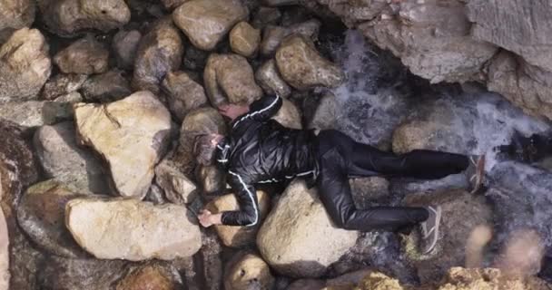 Kıyıda Bir Insan Cesedi Hisse Kıyısında Dalgalar Olan Kayalıklardaki Insan — Stok video