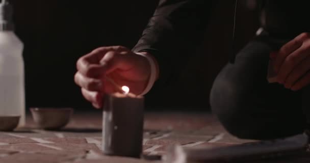 点着蜡烛举行仪式 人们正在地上点燃蜡烛 准备举行仪式 在撒旦仪式上拿着蜡烛的人 — 图库视频影像