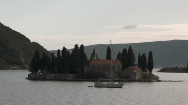 Ağaçları ve evi gölle çevrili küçük bir ada. Yaratıcı. Dağları olan güzel doğal bir arka plan 