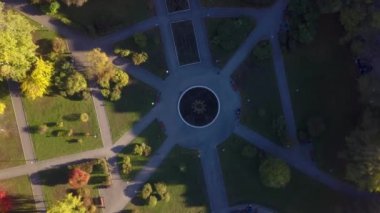 Güneşli bir sonbahar akşamında şehir parkının havadan görünüşü. Şarjör. Yolları, ağaçları ve yeşil otları olan park, peyzaj, yürüyüş ve açık hava eğlencesi için yer
