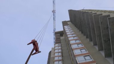 İnşaat süreci. Şarjör. Alt açıdan, özel ekipmanla tamamlanan büyük binaları vuruyorlar. Yüksek kalite 4k görüntü