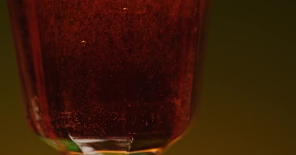 アルコールのカクテルで生きている ストッククリップ ウイスキーとコニャックとフルーツが付いた高価なアルコールが周りに横たわっている色の背景 高品質の4K映像 — ストック動画