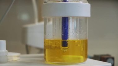 Laboratuvarda sıvı yağlı sarı solüsyon. Şarjör. Tıbbi araç, sağlık sektörü