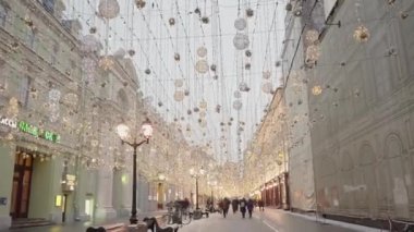 Kışın çelenkleri olan güzel yaya caddesi. Başla. Şehirdeki sokakta parlak ışıklar ve çelenkler. Kışın şehrin güzel, şenlikli süslemeleri. 